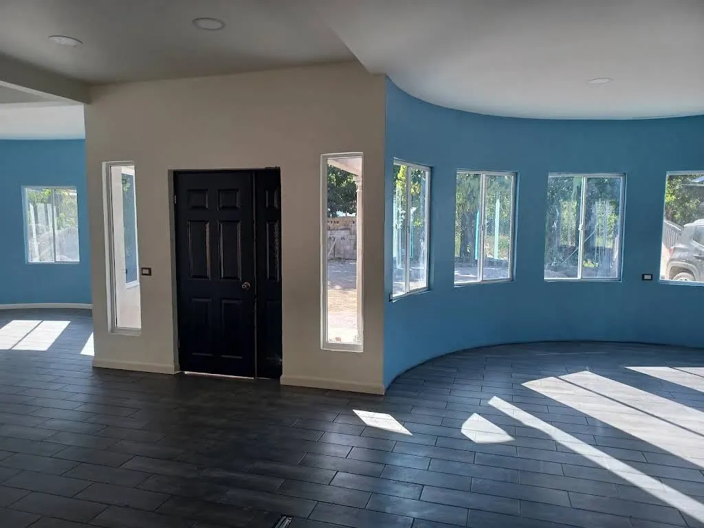 Living room with a curved wall painted deep teal and white trim