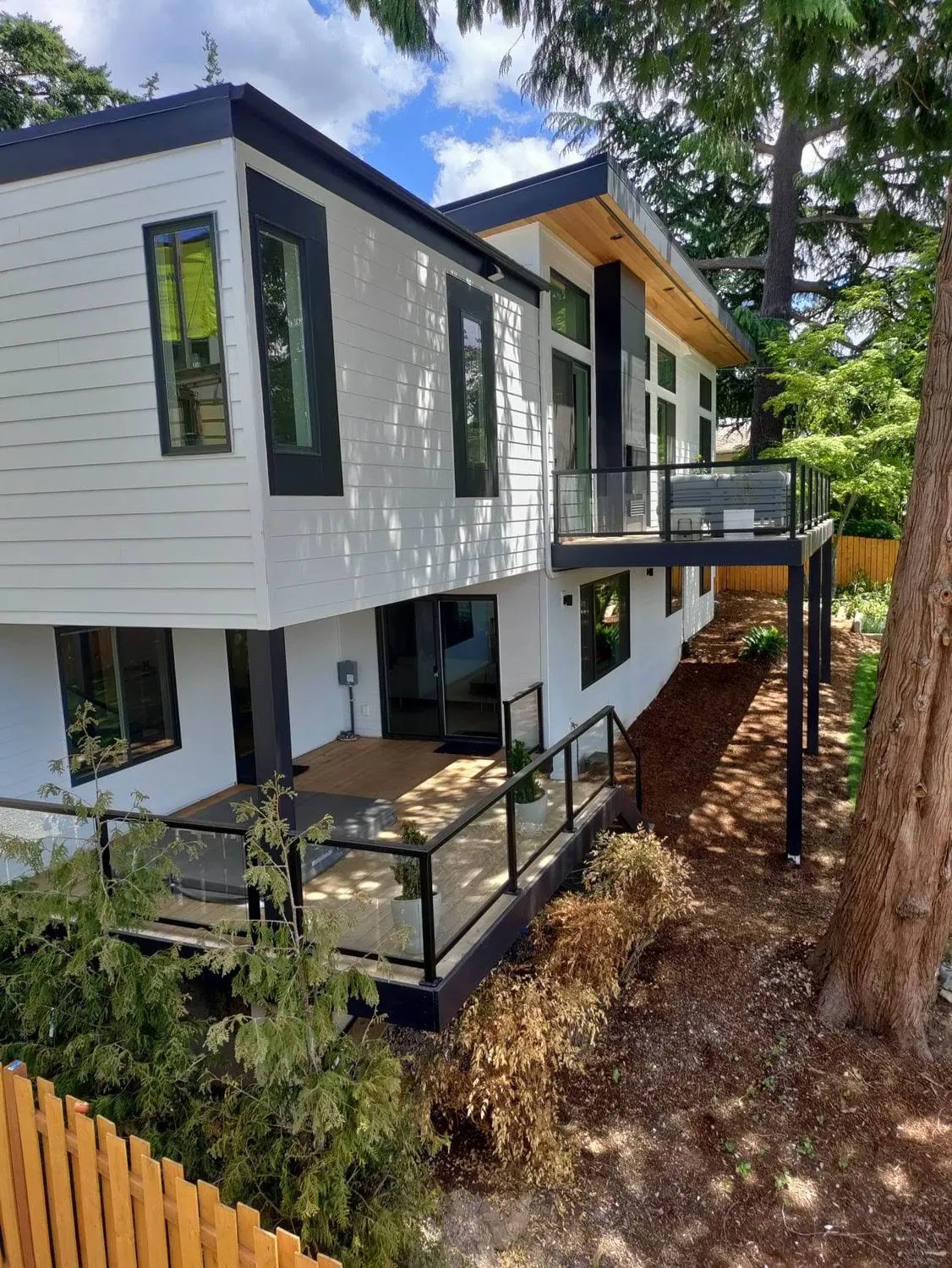 Modern home with white panels, cedar soffit and metal roof